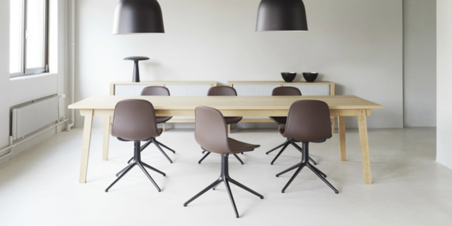 Meetingraum mit einen Konferenztisch in der Mitte und sechs Form Chairs in braun schwarz um den Tisch herum.